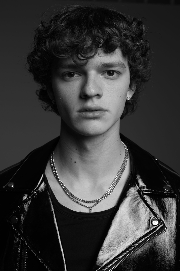 Modelo con chaqueta de cuero y cadenas al cuello representado por Generation Models