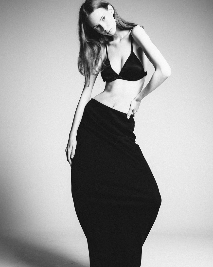 Modelo Kristina Popova con top negro con las manos alzadas