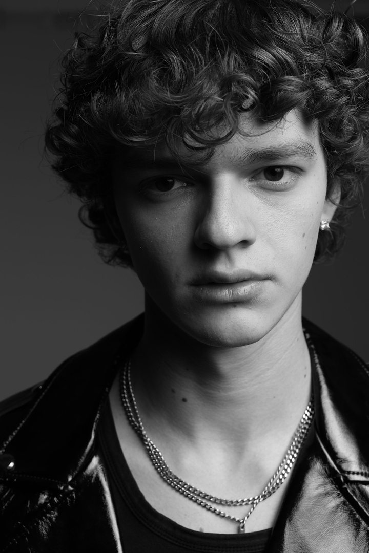 Modelo con chaqueta de cuero y cadenas al cuello representado por Generation Models
